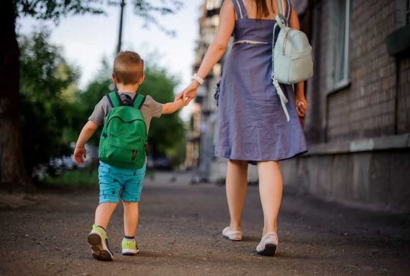 Mom walking holding kids hand 800x550